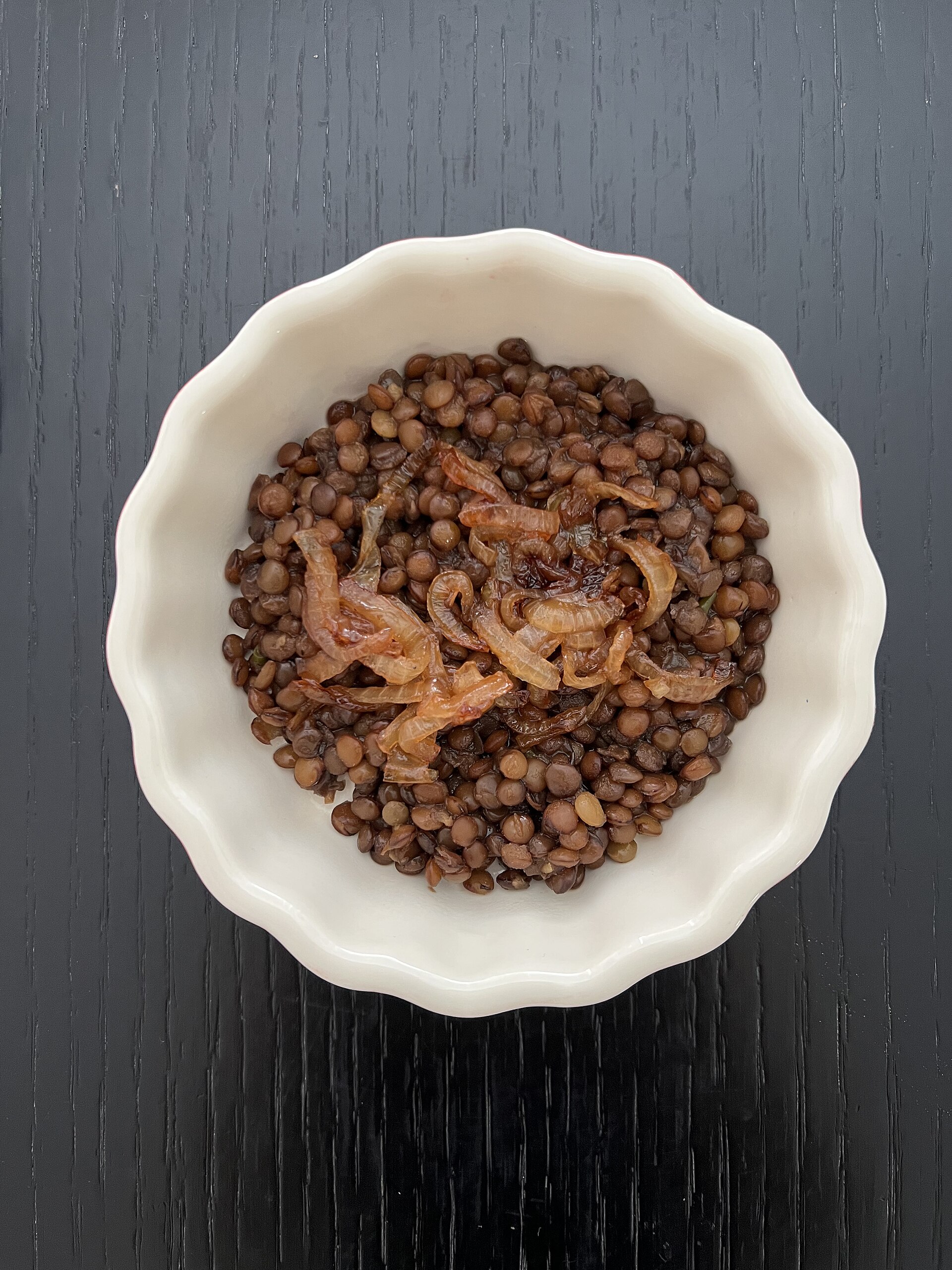 Bowl of cooked brown lentils with caramelised onions